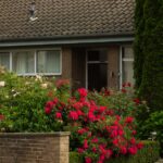 Cozy suburban brick house with vibrant garden and driveway.